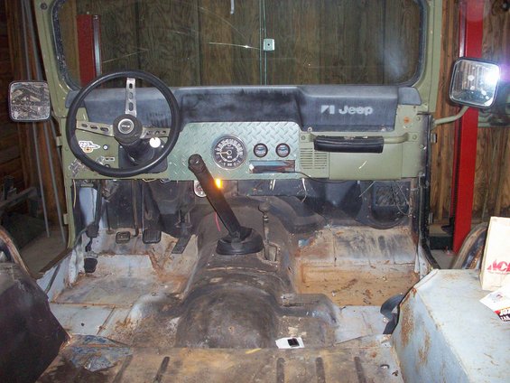 1978 Jeep CJ5 interior showing dashboard, steering wheel, shifter, and rusty floor pans