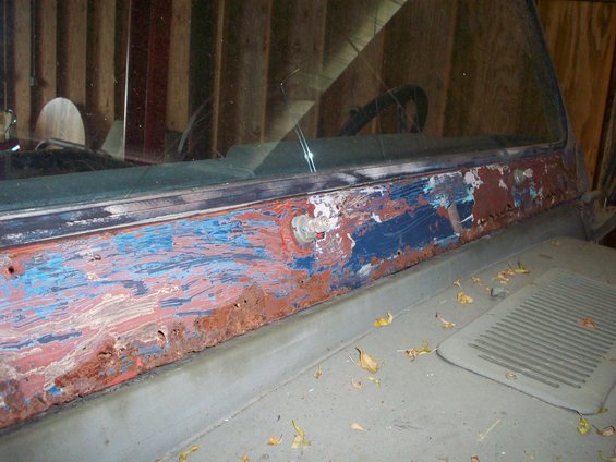 Jeep dashboard with peeling blue and red paint, rust, and a visible bolt