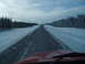 1995 Mercury Grand Marquis - View from inside a red vehicle driving on a snow-covered highway, with another truck visible in the distance.