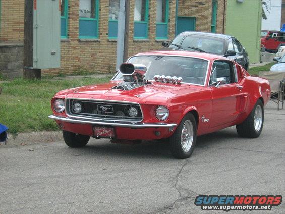 Red 1967 Ford Mustang with a big supercharger on the hood