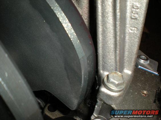 Close-up of a metal engine component with casting numbers '056' visible