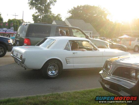 White 1965 Ford Mustang coupe parked next to other vehicles