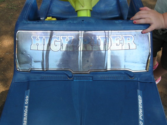 Blue toy truck dashboard with a chrome emblem reading "HIGHLANDER" and "460 POWERED" text