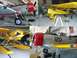2003 Ford Crown Victoria - Multiple aircraft, including a yellow seaplane, are stored inside a hangar with American flags visible.
