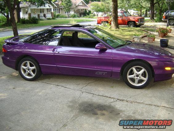 Purple 1994 Ford Probe GT parked on driveway, red pickup truck in background
