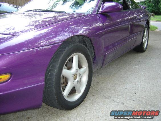 Purple 1994 Ford Probe, front passenger side view, showing alloy wheel and side body molding