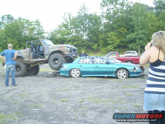 Lifted 1979 Ford Bronco crushing a teal sedan