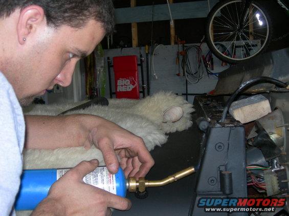 man using a torch on a vehicle's dashboard area