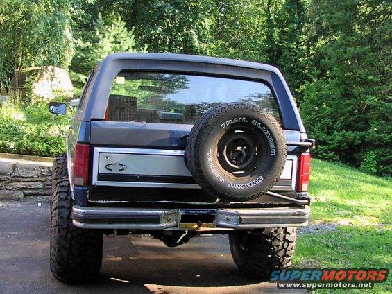 Dark blue Ford Bronco rear view with spare tire mounted on the back. Lifted suspension and off-road tires are visible
