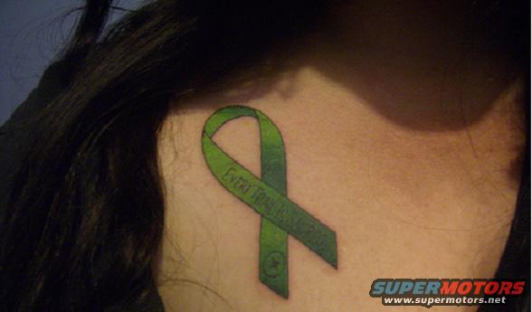 Green ribbon tattoo on neck with text "EVERY TRAIL