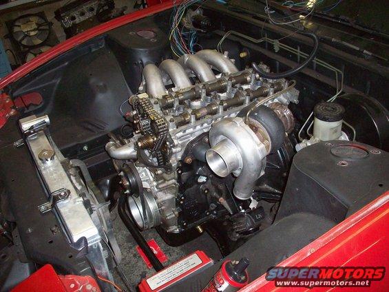Engine bay with a turbocharged engine, radiator, and wiring