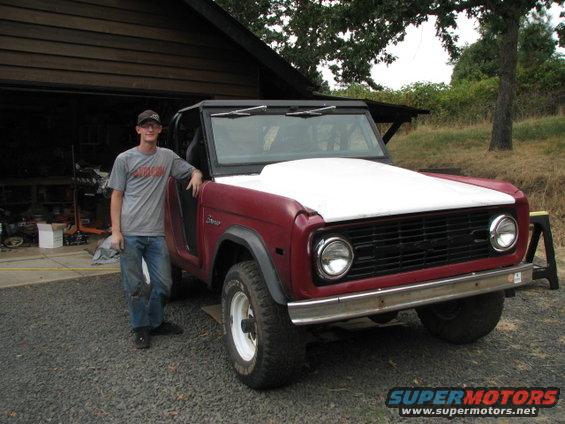 1968 Ford Bronco with a white hood and a person standing next to it