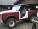 1968 Ford Bronco - A person sits in the driver's seat of a classic Ford Bronco, which appears to be undergoing some work.