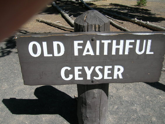 Wooden sign reading OLD FAITHFUL GEYSER