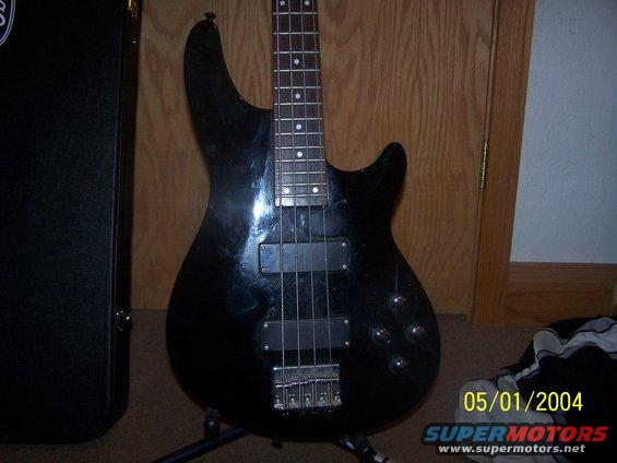 Black electric bass guitar on stand