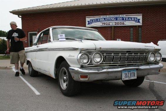 White 1962 Mercury Meteor with a man walking by