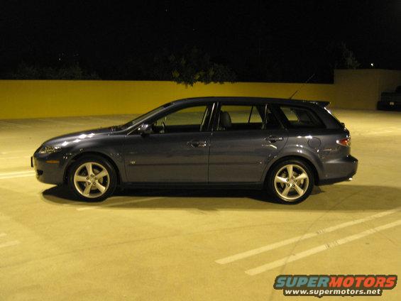 Side view of a dark blue Mazda 6 wagon parked at night