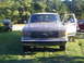1979 Ford F-250 - A 1987 Ford F-150 pickup truck is parked on grass with its driver's door open.