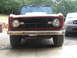 1968 Ford Bronco - Front view of a 1968 Ford Bronco with a red grille and white hood, parked outdoors.
