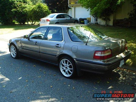 Gray sedan parked on street, another car in driveway behind it