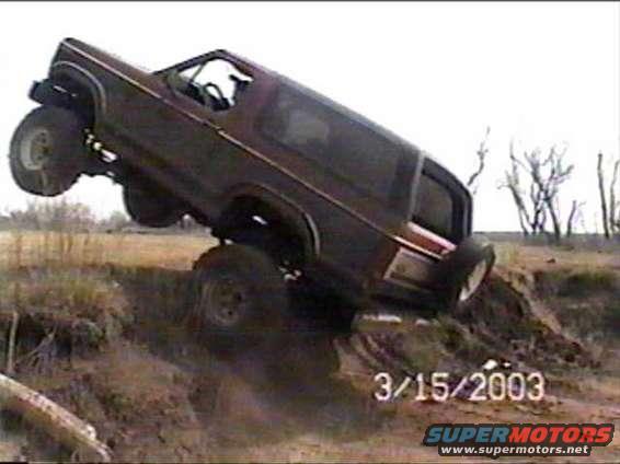 Ford Bronco tilted on its side going up a dirt embankment. Date stamp 3/15/2003 visible