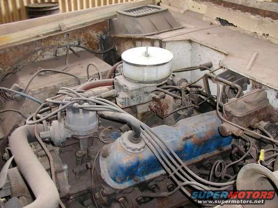Engine bay with V8 engine, air cleaner, distributor, and wiring. Some rust visible