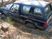1988 Ford Bronco - This SUV is stuck deep in the mud, with trees and foliage surrounding it.