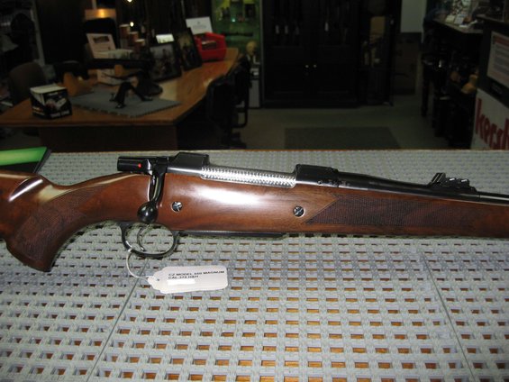 Rifle side view with wooden stock and metal bolt action