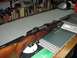 1991 Ford Bronco - A bolt-action rifle rests on a counter, with shelves of ammunition in the background.