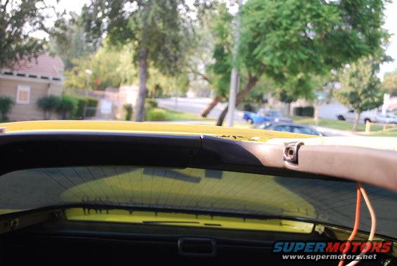 Yellow t-top interior with visible wiring and a glimpse of the rear window