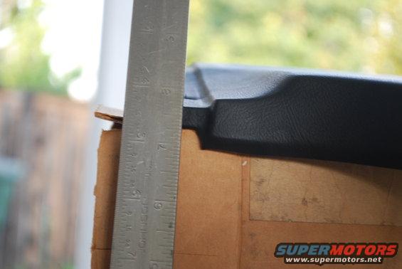 Close-up of black plastic trim with a metal ruler next to it, showing measurements