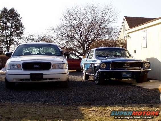 1968 Ford Mustang parked next to a white sedan