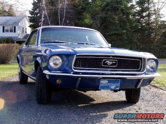 Blue 1968 Ford Mustang front view with a Mustang emblem on the grille and a Mustang plate on the bumper