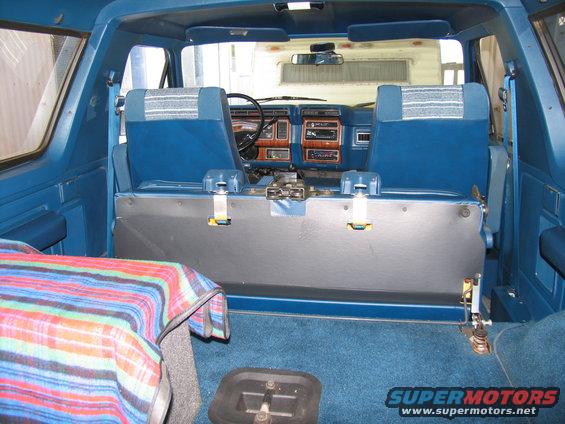 Interior of a 1984 Ford Bronco showing blue seats and dashboard