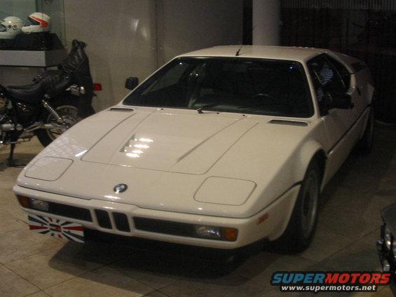 White BMW M1 front view, with a small Union Jack flag on the bumper