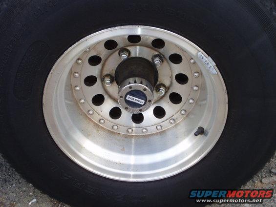 Close-up of a vehicle's wheel and tire with a WARN hubcap
