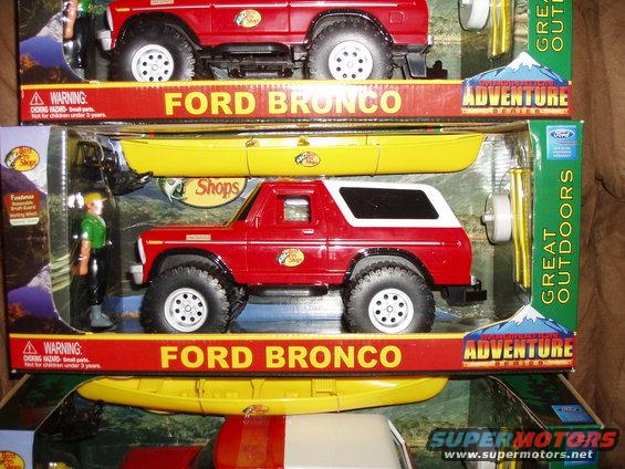 Two toy Ford Broncos in packaging, one with a yellow kayak accessory. The lower Bronco is red with a white top