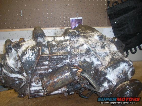 transfer case covered in grime and white residue, with some wiring visible