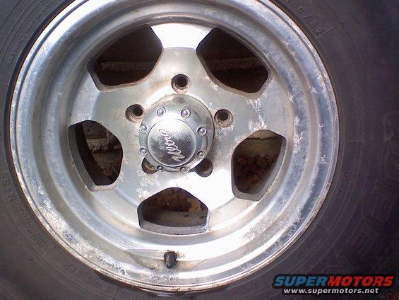 Chrome wheel with five spokes and a center cap with 'Weld' logo. Tire sidewall has text