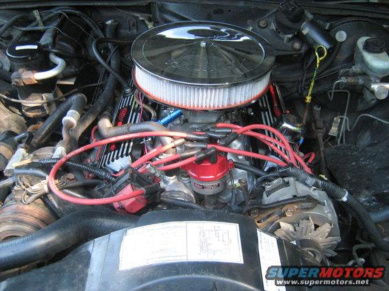 Engine bay with chrome air cleaner, red spark plug wires, and aftermarket valve covers