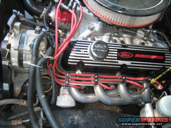 Close-up of a Ford Motorsport engine with red spark plug wires and a chrome air filter housing