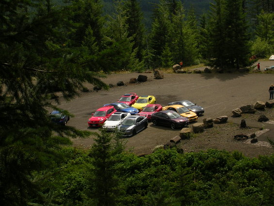 Cars parked in a lot with trees and rocks