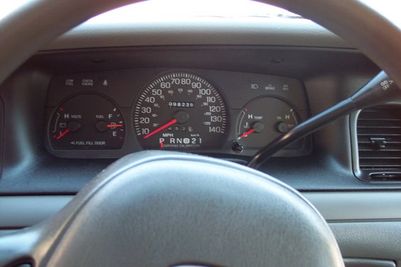 Dashboard of a 2001 Ford Crown Victoria showing speedometer, fuel gauge, and temperature gauge