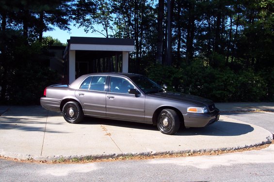 Gray 2001 Ford Crown Victoria parked on a concrete pad, viewed from the front three-quarter angle