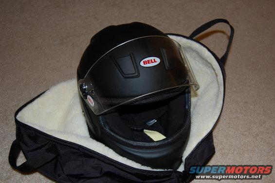 Black Bell helmet with clear visor, placed inside a black bag with a fuzzy white lining