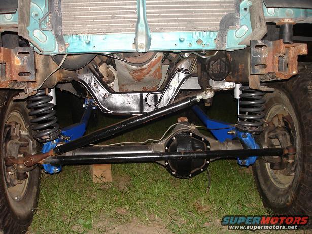 1996 Ford F-150 front suspension with blue control arms and aftermarket shocks, showing differential and radiator