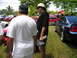 2009 Ford Mustang - Several Ford Mustangs are gathered on a grassy field under a partly cloudy sky.