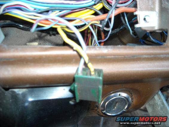 1978 Ford Bronco interior showing a complex wiring harness connected to a green connector and a chrome ignition cylinder