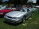 2009 Ford Mustang - A silver convertible Mustang is parked on grass, with other vehicles in the background.