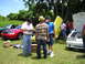 2009 Ford Mustang - Several Ford Mustangs are gathered outdoors, with people interacting around them.